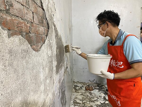 「行繕英雄」志工到弱勢家庭服務,修補破損牆面。圖/新北市政府提供