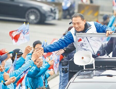 民進黨指侯辦公布凱旋苑租金補貼方案打假球,侯辦回應已說明聯絡窗口是「又昱」公司,反指賴清德面對違建或炒房爭議,始終閃躲迴避,國民黨總統候選人侯友宜(右)9日在林口車隊掃街,侯穿著印有國旗的外套,民眾也熱情揮舞著國旗。(陳怡誠攝)