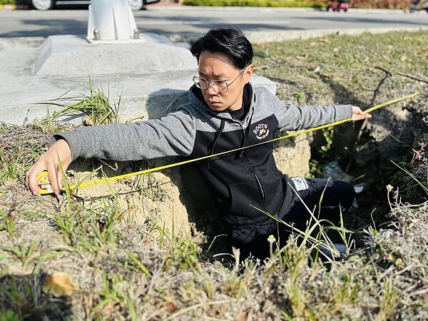 苗栗縣頭份市中央路的中央分隔島傳出發現「天坑」,縣議員陳光軒上午到現場量測,認為下方路基已被完全掏空。圖/取自陳光軒臉書