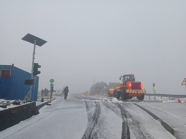 合歡山今晨降下大量霰夾雪，山上成銀白世界，鏟雪車今晨已出動剷雪，上山限加掛雪鍊通行。圖／公路局提供