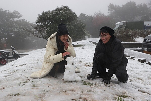 台北陽明山今天凌晨降下瑞雪，許多民眾到陽明山賞雪，在二子坪停車場堆起雪人。記者陳正興／攝影