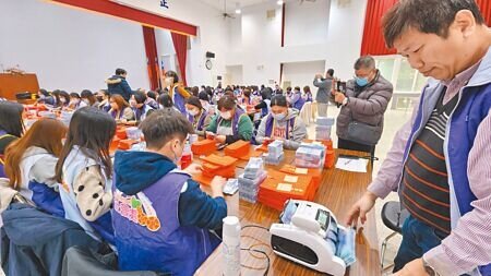 澎湖縣23日起普發長者5000元春節禮金,澎縣府社會處人員借用選委會2樓禮堂,在警方派員戒護下進行點鈔裝紅包袋作業。(許逸民攝)