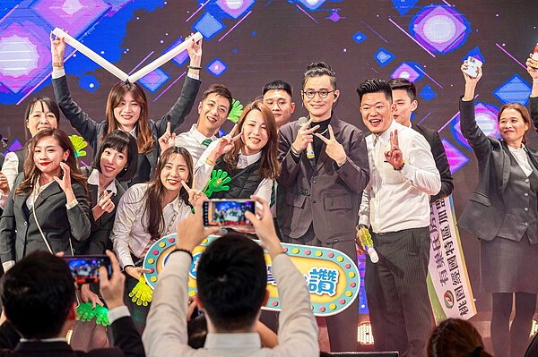 有巢氏房屋桃園尾牙請到唱匠卓義峰,同仁爭相上台合影留念。圖/永慶房產集團提供