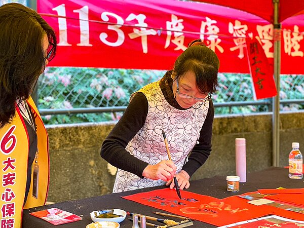 台北市內湖區康寧里里長鄭秀鳳親自揮毫春聯送給參加民眾,祝福新一年幸福平安。