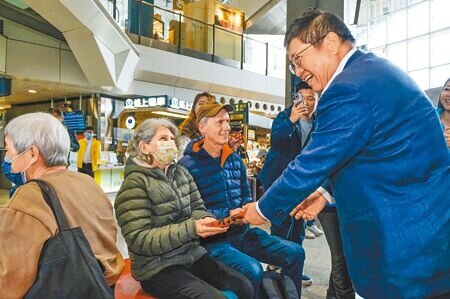 新竹縣長楊文科(右)7日到高鐵新竹站了解春節疏運情形,並在高鐵站大廳發送春聯和紅包袋,連外國旅客都感受到台灣過年氣氛。(羅浚濱攝)