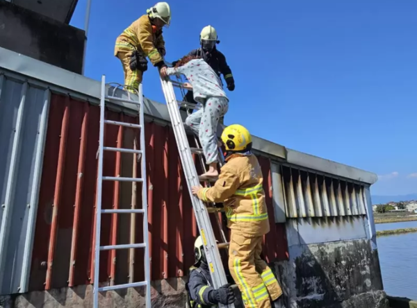 宜蘭市一處民宅起火，消防員從2樓後方陽台迅速救出受困31歲徐女。圖／宜蘭縣消防局提供

