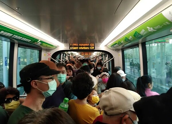 謝姓旅客擠在悶熱的輕軌車廂，一度在車上久候數分鐘都沒有移動。圖／讀者提供
