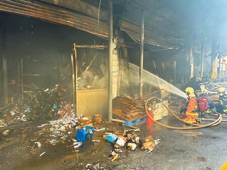 新北市深坑「中華大雄」工廠大火,火勢撲滅後,為避免復燃,消防局不斷灑水降溫、殘火處理及清理火場。(高鈞麟攝)