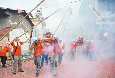 屏東市林仔內三山國王廟,信徒們24日將竹竿綁上鞭炮,衝炸神轎趨吉避凶。(林和生攝)
