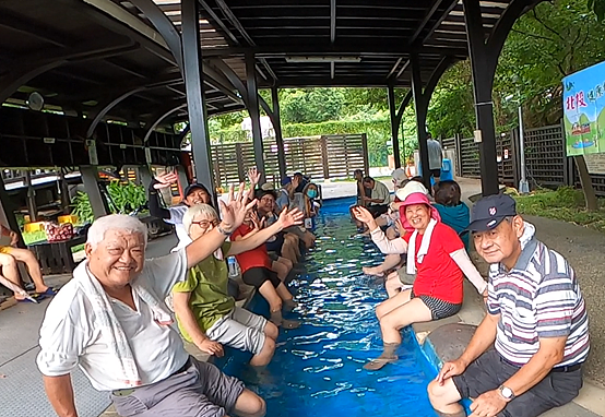長者們開心快樂在泉源公園泡腳池，享受溫泉泡腳放鬆的樂趣
。圖／台北市北投區健康服務中心提供