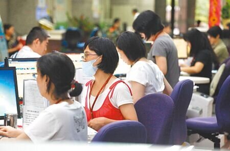 女力崛起!高普考行政類錄取率,女性囊括7成。圖為台北市政府女性員工辦理業務。(本報資料照片)