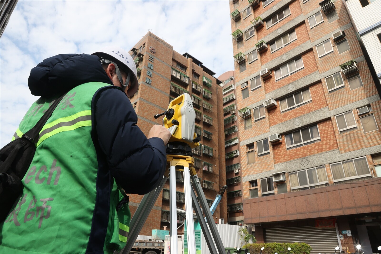新北市三重區福隆路新建案工地塌陷，現場管制人員用儀器測量房屋現況。記者邱德祥/攝影 