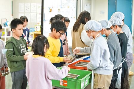 蘇丹紅辣椒粉風波持續燒，台北市轄內學校午餐暫緩使用辣椒粉、咖哩粉（含咖哩塊）等調味品。圖為台北市健康國小學生領取營養午餐。（杜宜諳攝）