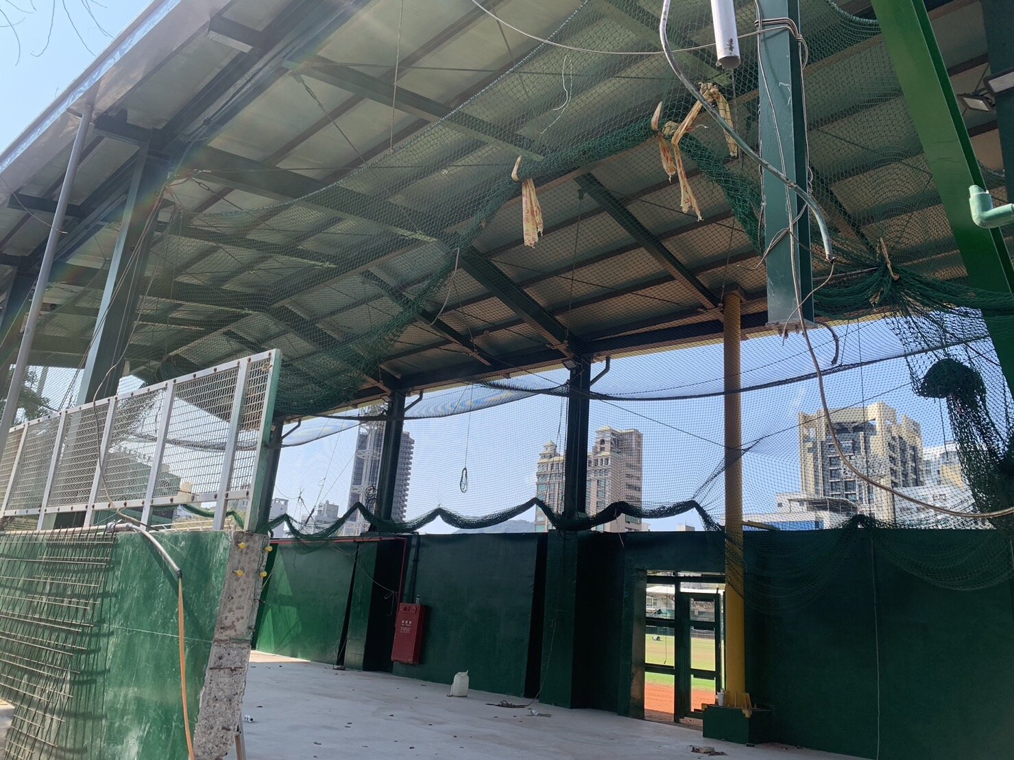 立德棒球場不僅鋼筋外露、牆壁龜裂、防護網散落各處,球場外圍更是凌亂不堪、雜草垃圾遍佈,居民擔心工程持續延宕。記者宋原彰/攝影