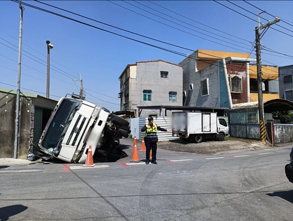 高雄市路竹區成功路223巷口1輛預拌混凝土車倒車時路面塌陷成1個大洞,車輪陷入坑洞,車體向右側翻,撞擊一旁存放海產的倉庫。記者王勇超/翻攝