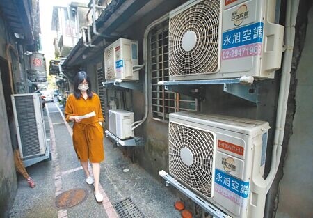 電價4月1日起調漲，今年夏天，民眾將看到史上首次「8元」驚人電價。圖為民眾經過許多冷氣室外機。（本報資料照片）