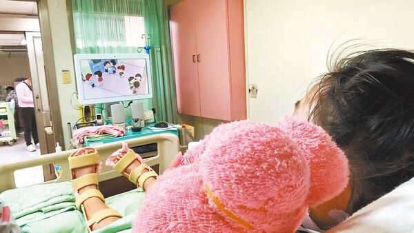 仍在彰化市秀傳醫院加護病房的陳姓姊姊18日在病床上觀看卡通影片，她的狀況逐日好轉中。圖／秀傳醫院提供