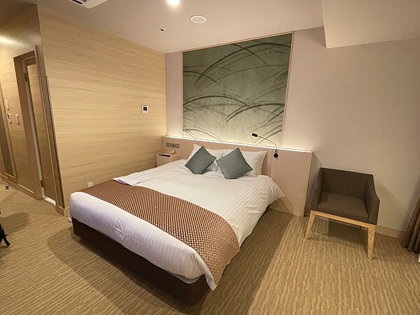 我們常住飯店會看到床上鋪著一條「長長的布」，它的專業名稱為床旗，類似於放在桌子上的桌旗，是為了防止弄髒床單。 圖／擷取自臉書粉專「魚漿夫婦」
