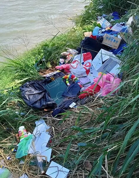 新北市環保局在茅埔路水岸旁發現垃圾後,破袋搜尋相關個資跡證開罰。圖/新北市環保局提供