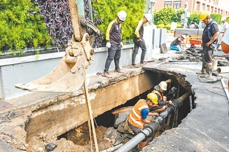 
新竹縣竹北市縣政七街「新業建設」社區大樓建案，因排水沖破底溝，造成瓦斯和自來水洩漏，開挖發現路面下土砂被淘空，水公司16日派員修復管線。（羅浚濱攝）
