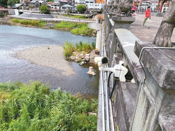 新北市環保局人員為查出浮渣來源，稽查員在三峽河沿線架設監視器24小時連續監測。圖／新北市環保局提供