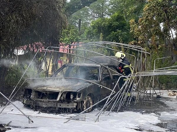 高雄梓官區一處戶外停車場發生火災，共5輛轎車、1輛機車遭剩鐵架，，火災起因為附近民眾燒野草時不慎引燃停車棚的帆布。記者宋原彰／翻攝
