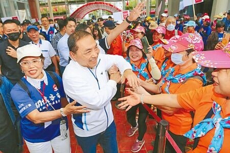 國民黨總統參選人侯友宜22日提出青年政策5大主張，將提供初入職場青年2年100萬意外險。圖為侯友宜（前排左二）22日參加台北客家義民嘉年華挑擔奉飯活動，向熱情民眾一一握手致意。（黃世麒攝）