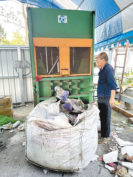 
埔里鎮清潔隊人員23日將大型包裝袋、塑膠袋等壓縮、打包，累積一定數量再變賣，想方設法力行垃圾減量。（楊靜茹攝）
