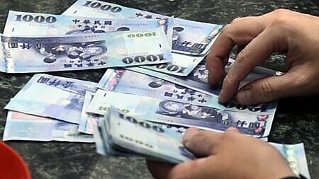 隨外資熱錢持續匯出,新台幣轉貶,終場收在32.348元兌1美元,創逾七年新低收盤價。圖∕本報資料照片