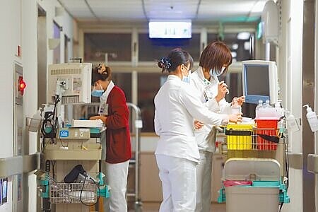 圖為護理師為病人準備藥物。(本報資料照片)