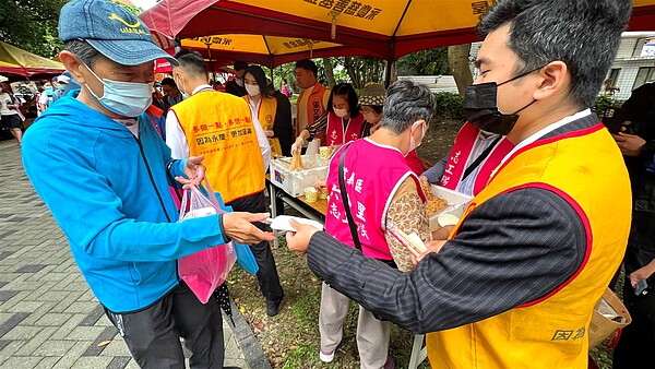 台北市信義區六合里重陽活動，永慶房屋擔任活動志工，發送美食、點心給參加活動的長輩們。圖／永慶房產集團提供