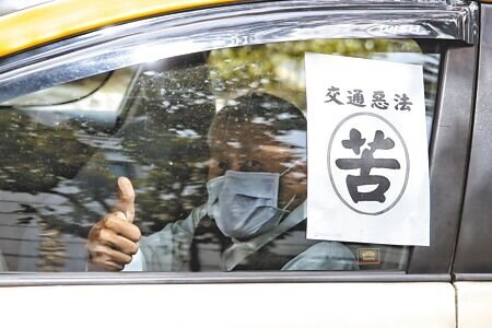
全國汽車駕駛人權益聯盟31日動員數十輛計程車、遊覽車包圍交通部抗議，現場與會的計程車皆在車上貼上「苦」字。（杜宜諳攝）
