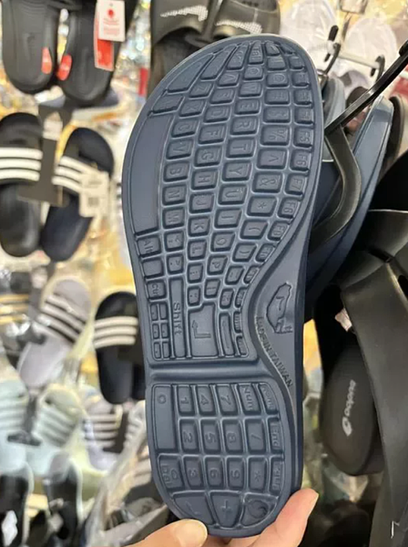 有網友發現拖鞋的鞋底印著電腦的鍵盤圖,一旁還有一個台灣全島的圖案寫上7的字樣,下方還註明MADE IN TAIWAN。 圖擷自臉書社團「路上觀察學院」