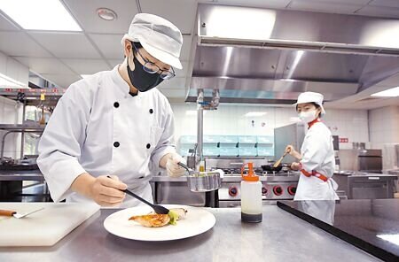 近年來高職及大專院校餐旅科系學生人數銳減,疫後觀光缺工問題嚴重。圖為萬能科大學生正在練習擺盤。(范揚光攝)