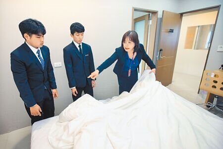 疫情解封後餐飲旅宿業卻嚴重缺工,許多業者紛紛祭出高薪吸引相關科系學生。在萬能科技大學觀光餐旅暨管理學院的教室內,老師向學生示範鋪床的技巧。(范揚光攝)