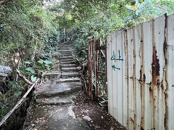 北市北投區溫泉路前往北投真言宗石窟建築群的步道會行經私地,一旁鐵皮圍籬老舊無人整理。圖/林延鳳研究室提供