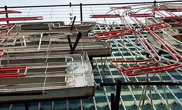 北市亞洲廣場大樓27樓頂的大型廣告物年久失修,細碎物與燈飾屢被吹落影響公共安全。圖/北市議員洪婉臻提供