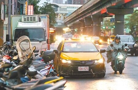 
今年6月30日上路的交通新制中，交通部檢討後擬恢復併排臨停要記點。圖為計程車在路邊併排臨停。（范揚光攝）
