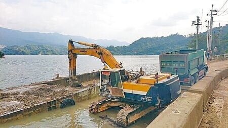 政府把「加速水庫清淤」列為重要政策,共鎖定13座嚴密監視。圖為曾文水庫以抓泥船夾起淤砂,以小船將淤砂船艙拖回碼頭。(程炳璋攝)