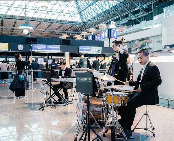 龍潭愛樂管絃樂團在桃園國際機場演奏望春風等名曲,催生機捷第1億5千萬人次旅客。圖/桃園市府提供