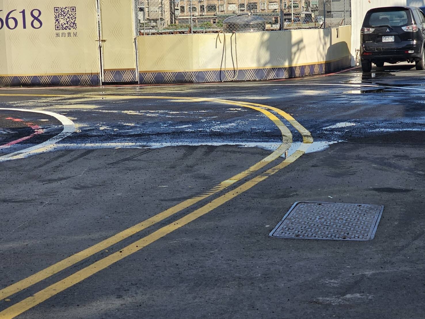 台中市沙鹿區一處建案工地旁路面,日前出現二個大坑洞,記者今天到場觀察,大洞早已填平,一旁有工地人員監看。記者游振昇/攝影