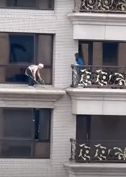 民眾目擊有清潔人員站在20樓窗台清掃。圖/翻攝自爆料公社二社