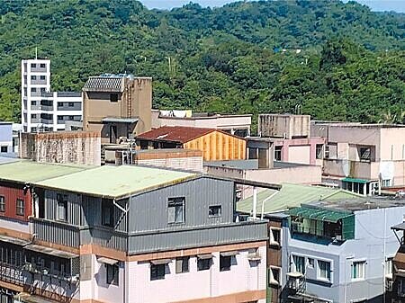 基隆市老屋多又多雨,民眾往往會在屋頂搭建鐵皮,經議員提案修法,高度已放寬至2.1公尺,將自12月4日起實施。(徐佑昇攝)