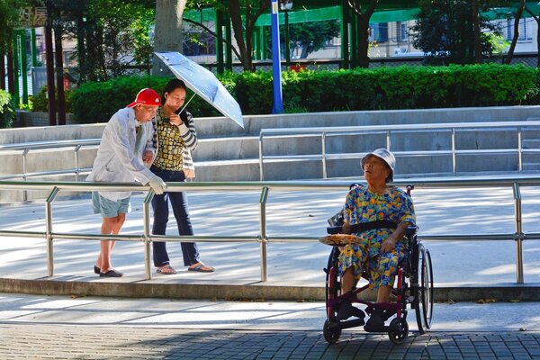 新北市中和區秀山公園,四點多時外傭看護帶著老人散步,另一名老人則被另一位不負責任的看傭扔在一旁睡覺。(好房News記者 陳韋帆/攝影)