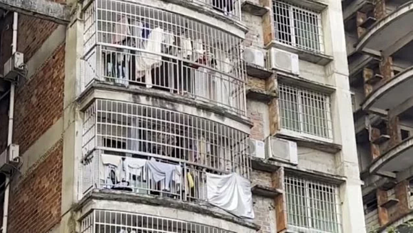 爛尾樓外景,掛著的衣服顯示樓內住滿了人。(取材自每日經濟新聞)