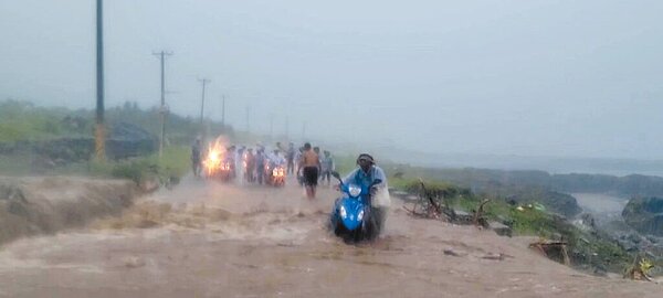 台東縣蘭嶼鄉28日降下大雷雨,土石流沖刷至蘭嶼環島公路,民眾互相扶持、涉水通過。(民眾阿樂本提供/蔡旻妤台東傳真)