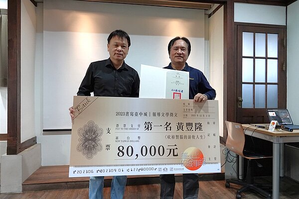 去年報導文學獎頒獎典禮台中文化局副局長曾能汀與第一名黃豐隆合影。圖/台中市政府提供