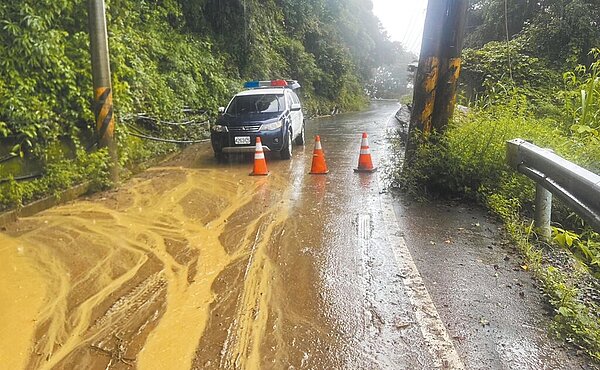 近日南投山區持續降雨,投89線21.4K上方土石滑落淹沒道路,尚無法預計何時能通行,建議民眾避免進入山區活動或改道通行。(南投縣警察局提供/張妍溱南投傳真)