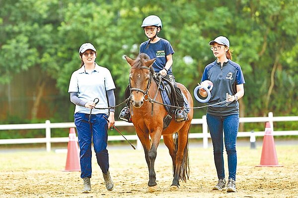 桃園市希望馬場是全台少數專業馬術治療場域,卻面臨建物無法合法化,身障家庭「馬背上的希望」面臨困境。圖/張兆遠提供