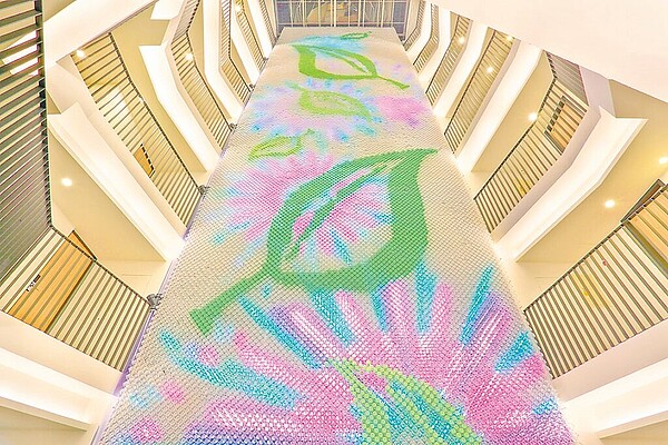 為響應環境永續,業者「綠宿行旅」回收約2.6萬寶特瓶結合LED燈打造「心之光牆」,向旅客傳遞友愛地球與永續生命的觀念。(業者提供/潘虹恩台中傳真)